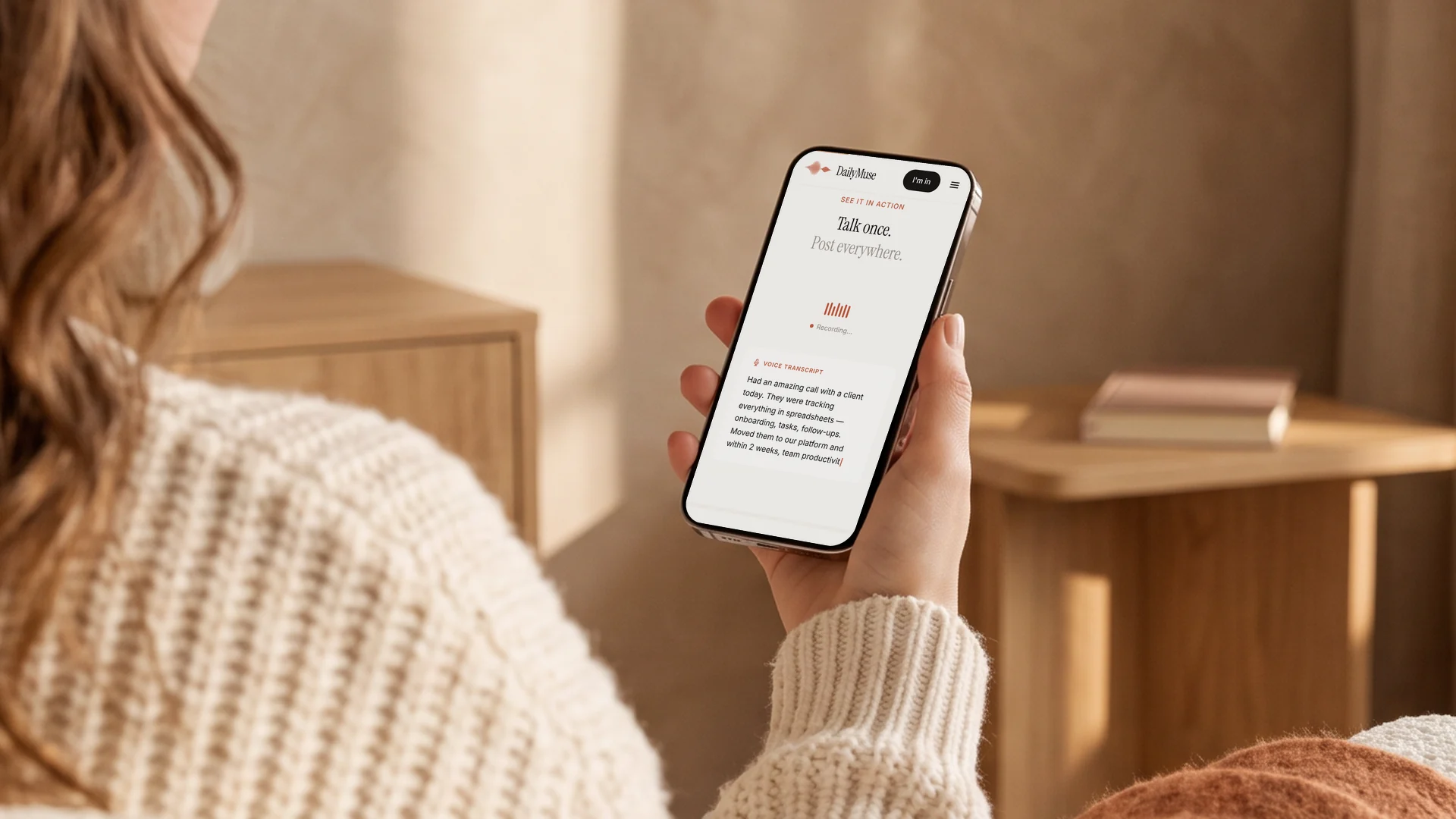 Eine Hand hält ein Smartphone, auf dem DailyMuse eine Sprachnotiz aufnimmt und live transkribiert: Talk once. Post everywhere.